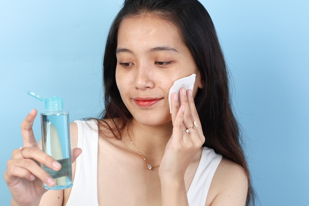 chica limpando cara tónico facial